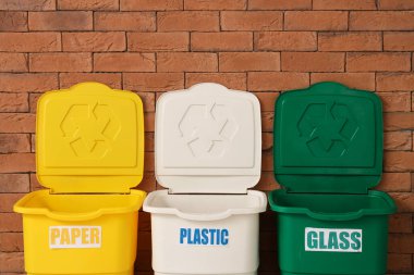 Tuğla duvarın yanındaki farklı çöp kutuları için boş çöp kutuları. Geri dönüşüm kavramı