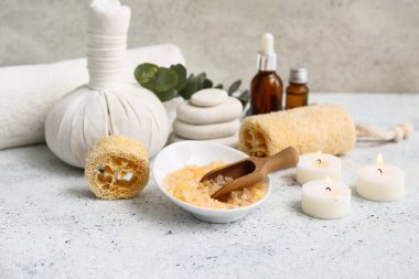 Lifli güzel kompozisyon, bitkisel çanta, deniz tuzu, gerekli yağ şişesi ve grunge arkaplanda mumlar.