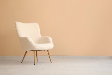 Bej duvarın yanında rahat bir koltuk