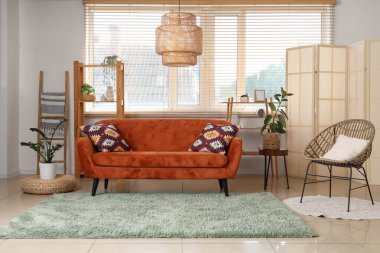 Odanın içinde ahşap merdiven, kırmızı kanepe ve raf üniteleri var.