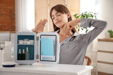 Kozmetik ürünleri için küçük buzdolabı olan güzel bir kadın.