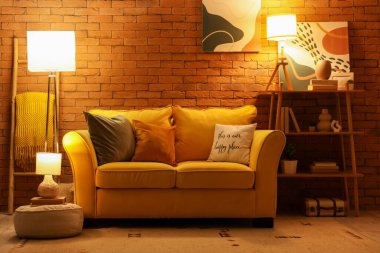 Oturma odasının şık bir iç mekanı. Akşamları kanepe ve parlayan lambalar.