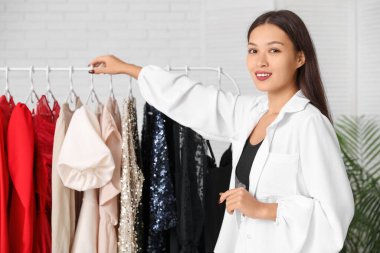 Mağazadaki elbise rafının yanındaki güzel genç bayan.