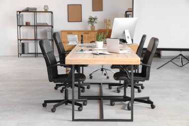 Masası ve raf ünitesi olan konferans salonu.