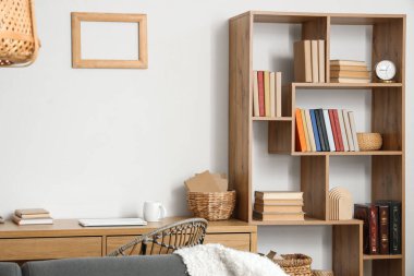 Kitaplığı ve işyeri olan oturma odasının içinde.