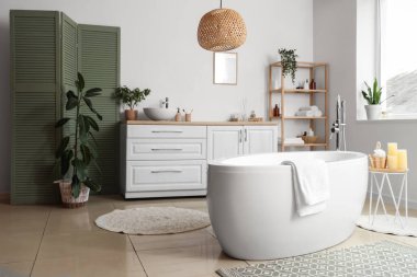 Banyonun içinde küvet, çekmeceler ve katlanır ekran var.