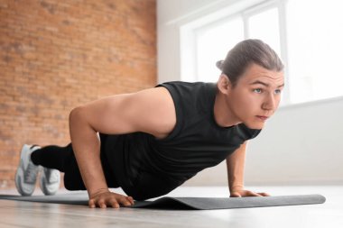 Sportif genç adam spor salonunda paspas eğitimi alıyor.