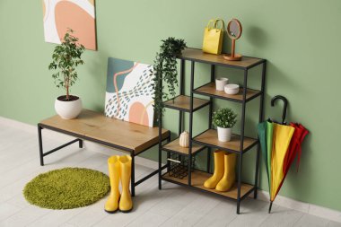 Koridorun içinde bank, raf ünitesi ve çizme var.