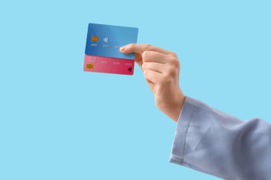 Mavi arka planda kredi kartı olan bir kadın.