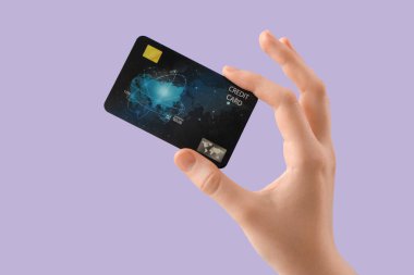 Leylak arka planında kredi kartı olan bir kadın, yakın plan.