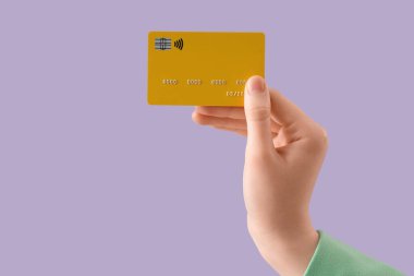 Leylak arka planında kredi kartı olan bir kadın, yakın plan.