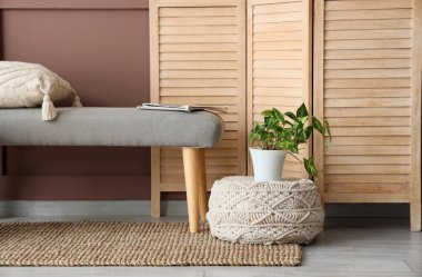 Yumuşak bank, katlanır perde ve kahverengi duvarın yanında pouf oturma odasının içinde, yakın çekim