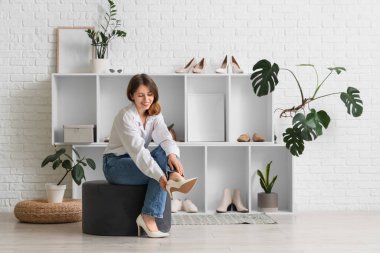 Koridorda topuklu ayakkabı giyen genç bir kadın.