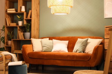 Kitaplık, kanepe ve gece lambasıyla oturma odasının içinde.