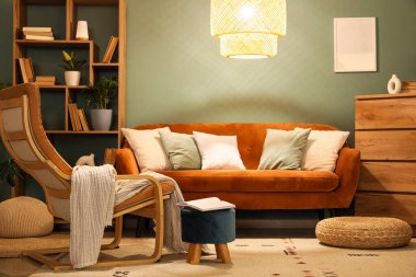 Kitaplık, kanepe ve gece lambasıyla oturma odasının içinde.