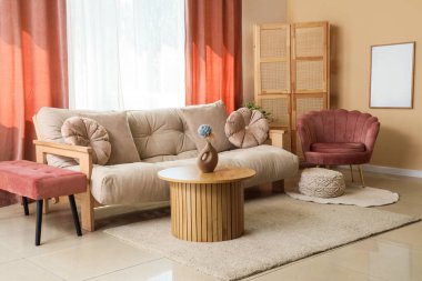 Pembe perdeleri, kanepesi ve koltuğu olan şık bir oturma odası.