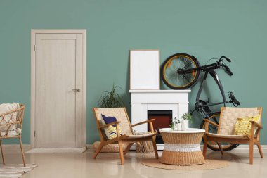 Bisikletli, şömineli ve koltuklu bir oturma odası.