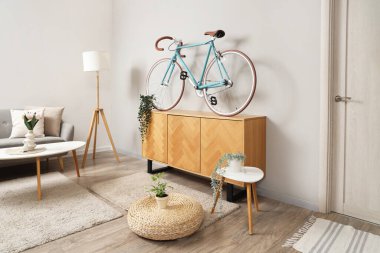 Bisiklet, klozet ve masalarla aydınlık oturma odasının içi