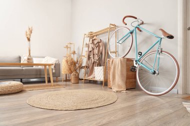 Bisiklet, palto askısı ve kanepesi olan ışık odasının içinde.