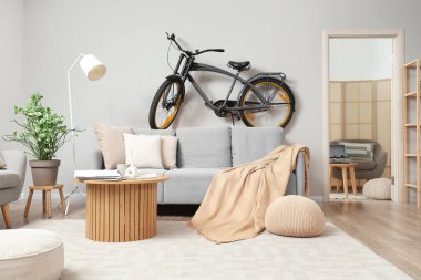 Modern bisikleti, kanepesi ve açık kapısı olan bir oturma odası.
