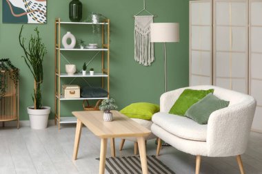 Rahat kanepesi, zeytin yastıkları ve ahşap masası olan modern oturma odasının içinde.