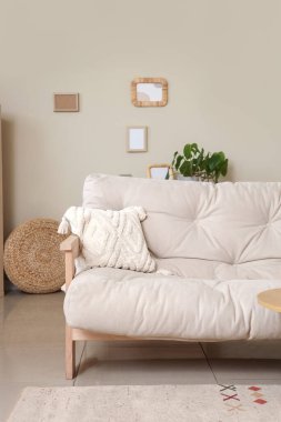 Kanepesi ve çerçeveleri olan rahat bir oturma odası.