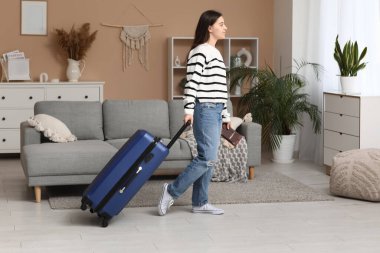 Evinde mavi bavullu genç bir kadın var. Seyahat kavramı