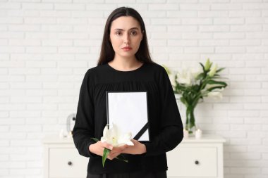 Nilüfer çiçeği ve fotoğraf çerçevesi olan genç bir kadın.