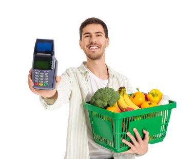 Beyaz arka planda alışveriş sepeti ve ödeme terminali olan genç bir adam.