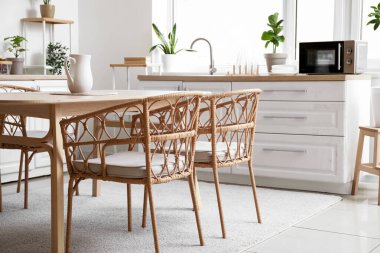 Modern mutfağın içinde yemek masası ve sandalyeler.