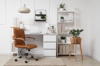 Çalışma yeri, modern laptop ve rahat koltuğu olan şık bir ofis.