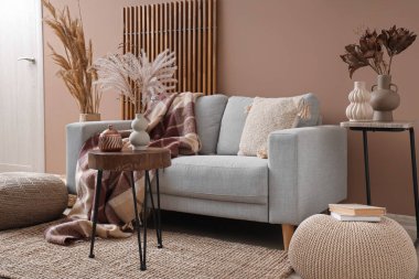 Kanepesi, masaları ve kuru sazlıkları olan şık bir oturma odası.