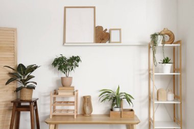 Yeşil çiçekli, bank ve raf üniteli aydınlık oturma odasının içinde.