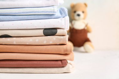 Masadaki bebek kıyafetleri yığını grunge arka planına karşı, yakın plan