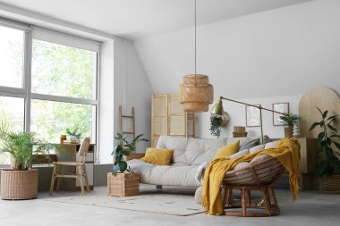 Rahat bir kanepe ve oturma odasının içinde çiçekli hasır sepetler.