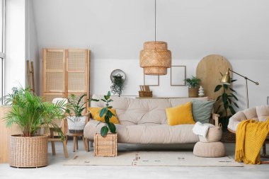 Rahat bir kanepe ve oturma odasının içinde çiçekli hasır sepetler.