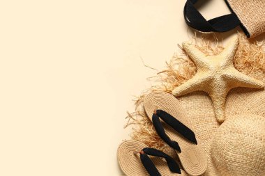 Parmak arası terlikli yaz şapkası, deniz yıldızı ve bej arka planda çanta.
