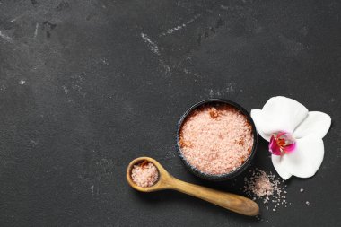Orkide çiçeği, kaşık ve kase ile kompozisyon ve siyah grunge arka planda deniz tuzu