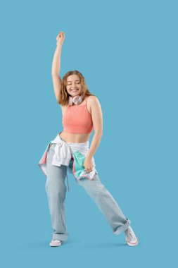 Mavi arka planda dans eden havalı genç bir kadın