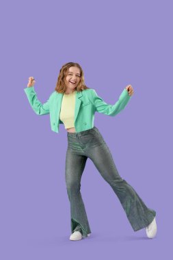 Havalı genç bir kadın leylak arka planda dans ediyor.