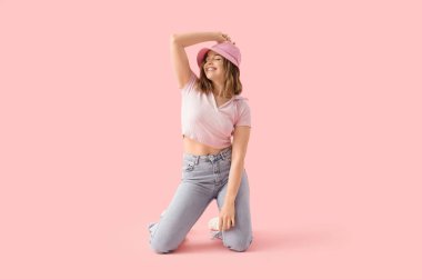 Pembe arka planda dans eden havalı genç bir kadın