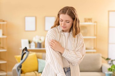 Temizlik yaparken kendini kaşıyan genç bir kadın. Alerji konsepti