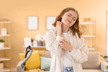 Temizlik yaparken kendini kaşıyan genç bir kadın. Alerji konsepti