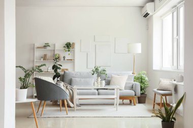 Rahat bir kanepe, yer lambası, masa ve koltuk oturma odasının içinde.