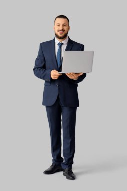 Dizüstü bilgisayarı olan yakışıklı bir iş adamı.