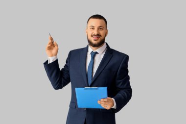 Açık arkaplanda panosu olan yakışıklı bir iş adamı