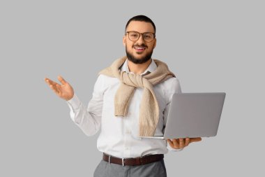 Diz üstü bilgisayarı olan erkek öğretmen.