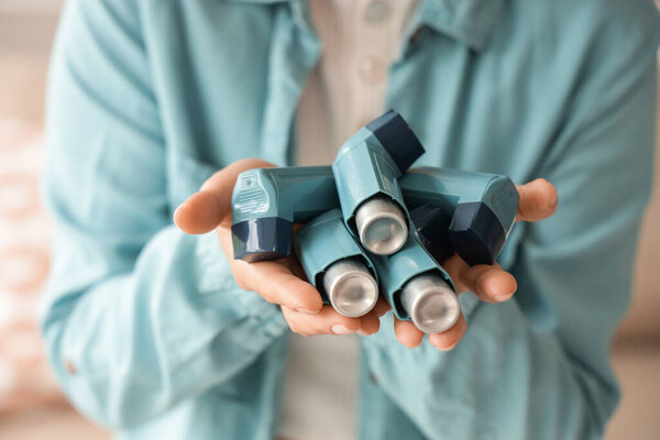 Молодая женщина с ингаляторами дома, крупным планом