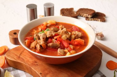 Beyaz arka planda bir kase lezzetli biftek yahnisi.