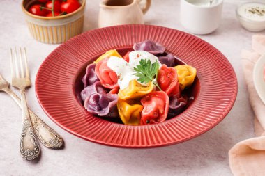 Beyaz arka planda ekşi kremalı ve maydanozlu kaynamış renkli hamur köfteleri.